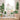 Hand-painted evergreen tree wall decal featuring a tall pine with layered green foliage and a textured brown trunk. Below, soft rounded bushes add depth and contrast, creating a peaceful forest scene—perfect for nursery or woodland-themed wall decor.